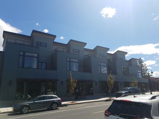 Modern mixed-use commercial building with clean storefront and upper-story windows in Bend